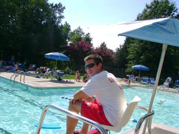 Lifeguard in tall chair overlooking pool